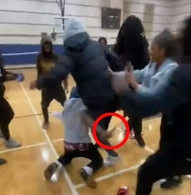 Students at a North Carolina high school are seen in a mass brawl in the gym on Monday, while a man in a gray hoodie is seen holding a knife.  The teenage suspect is accused of stabbing Ferrell to death