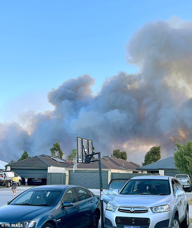 Smoke rises over Banksia Grove in Perth's northern suburbs, where bushfires have forced evacuations and lost homes