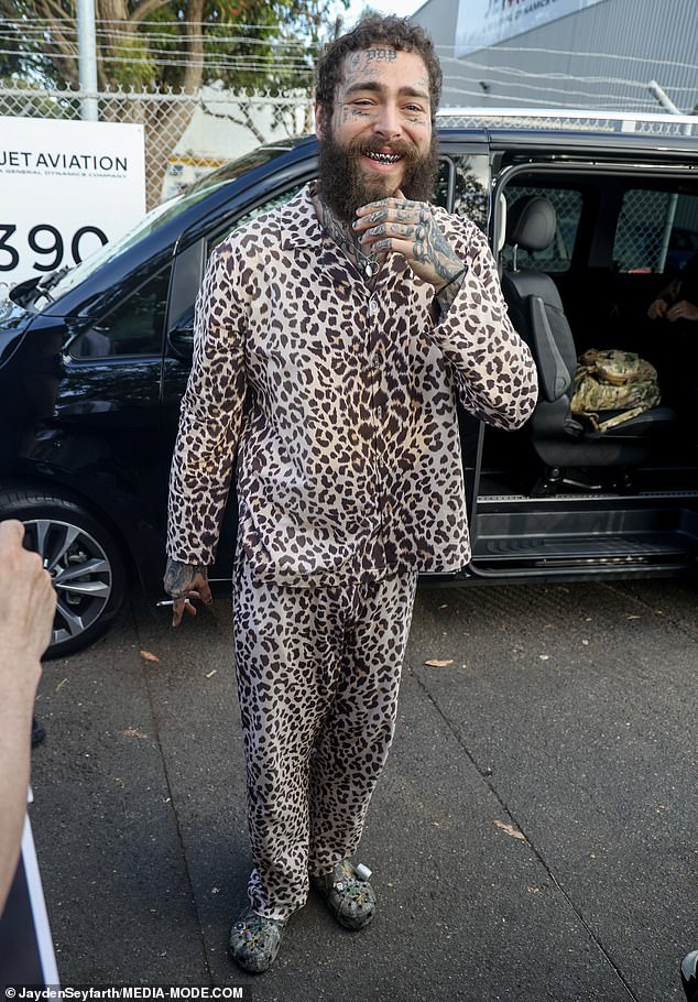 Rapper Post Malone, 28, opted for his signature unkempt look in leopard print pajamas as he puffed on a cigarette after flying to Sydney on Tuesday ahead of his world tour shows