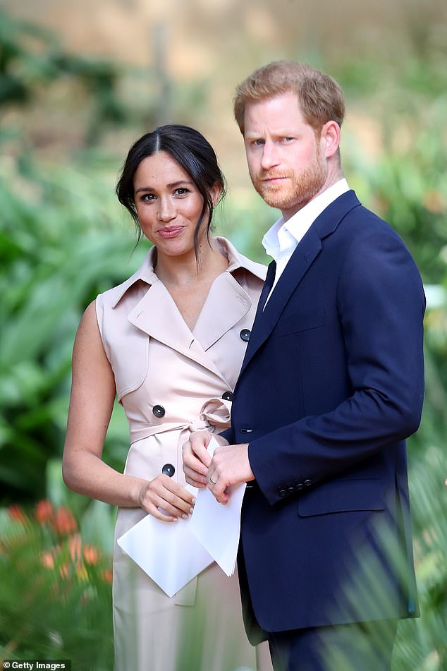 Harry and Meghan (pictured in Johannesburg in 2019) should distance themselves from Omid Scobie's explosive book as racing has deepened even further today, royal experts claim