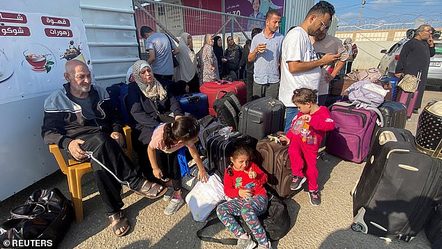 Palestinians with dual nationality wait outside the Rafah border crossing with Egypt