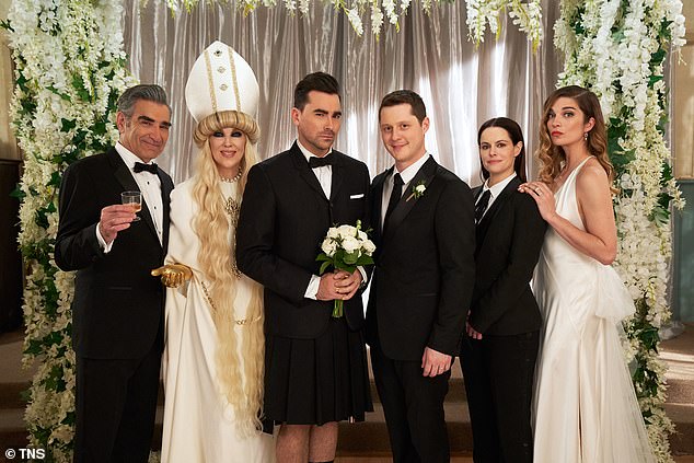 Schitt's Creek star: Hampshire, pictured second on the distant R in the suit, played Stevie Budd in the hit series