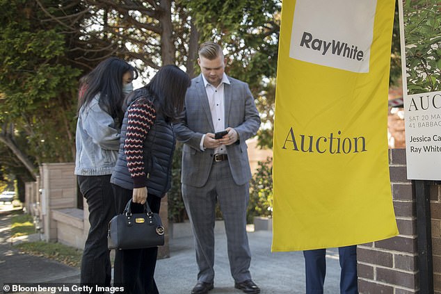 House prices in Australian cities are rising by double digits in less than a year, despite a dozen rate hikes (pictured is an auction in Sydney)