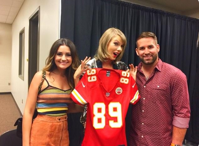 Fans of Taylor Swift have found a photo of the pop star posing in a Chiefs jersey next to former Kansas City star Chase Daniel (right) and his wife Hillary (left)