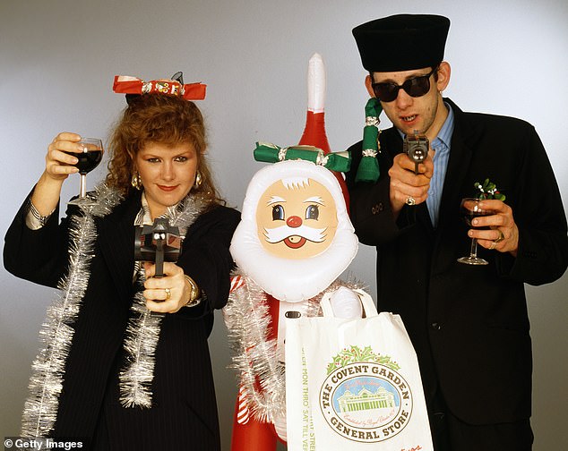 Singers Kirsty MacColl (1959 - 2000) and Shane MacGowan, whose death at the age of 65 was announced today, with toy guns and an inflatable Santa Claus as they promoted their 1987 hit Fairytale of New York