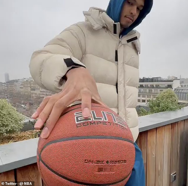 19-year-old Wembanyama is seen holding a basketball with his middle finger and thumb