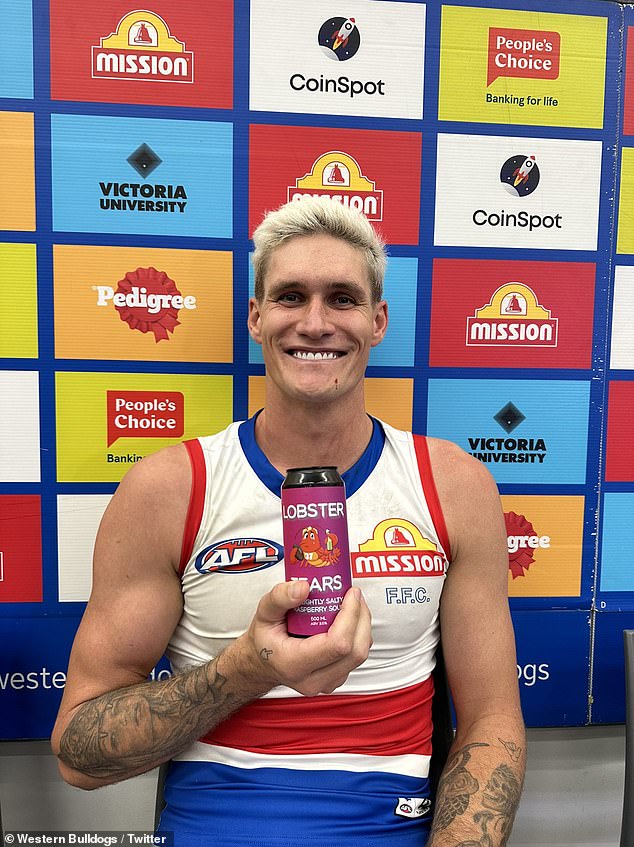 Lobb poses for a photo with a can of Lobster Tears beer made by Dockers fans to sled him on his return to Perth