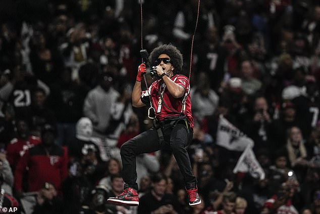 Rapper Ludacris rappelled through Mercedes Benz Stadium during the Falcons game