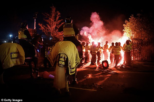 Police horses watch as officers in riot gear confront the group of thugs in Birmingham