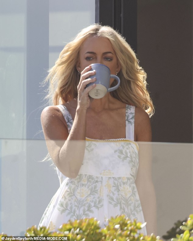 She also let the wind blow through her luscious blonde locks as she sipped a cup of coffee outside