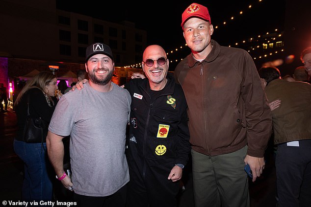 Basketball star Blake Griffin, 34, posed for a photo with Howie Mandel, 68, and his son Alex.  The athlete wore a brown windbreaker, olive green pants and a red hat