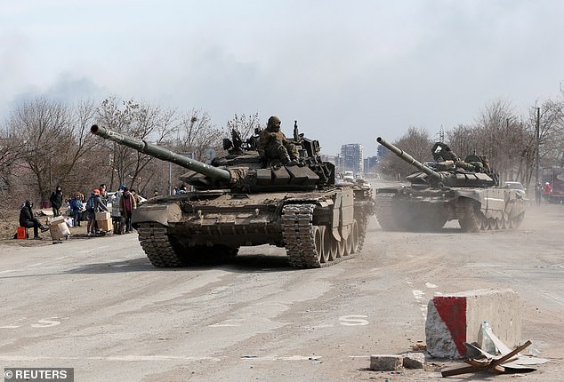 Russian troops sit on tanks on the outskirts of the southern port city of Mariupol, Ukraine, on March 20, 2022