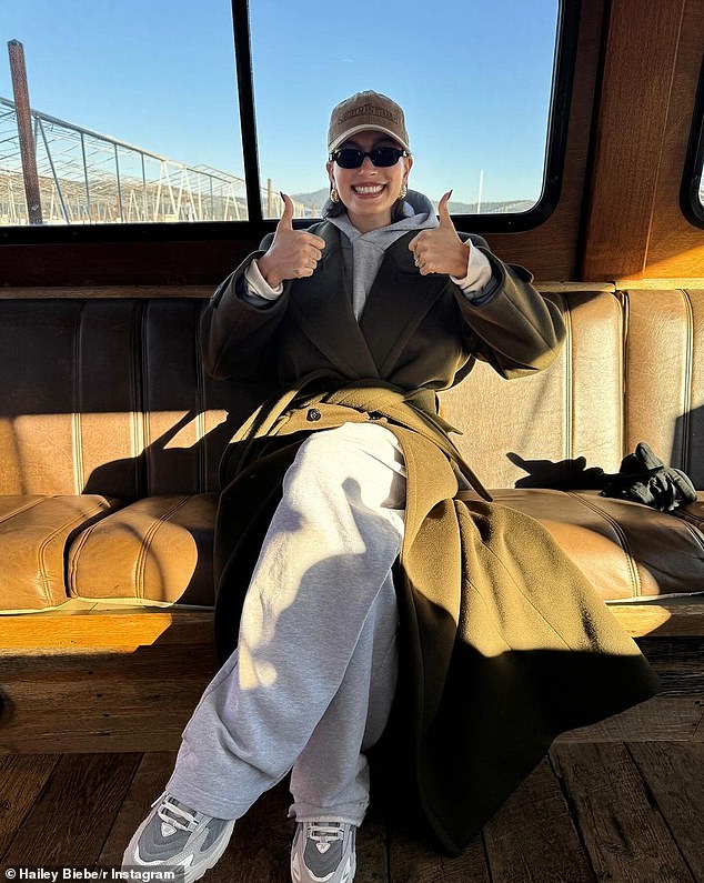 Bieber also showed her 50.7 million followers what appeared to be the inside of a train as she sat in a gray marl tracksuit with an olive green jacket and a Siegelman Stable hat.