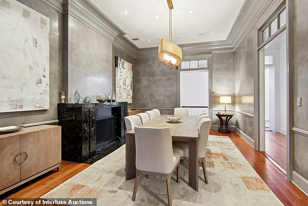 The dining room is finished with sleek Venetian plaster walls and a black marble mantelpiece