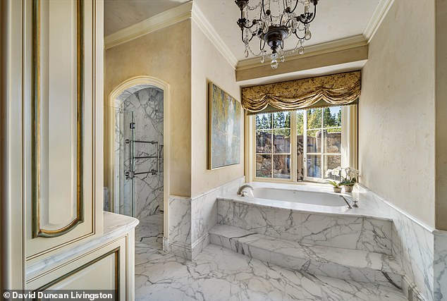 Other luxurious amenities include a dramatic formal dining room, a living room with a bar, a wine cellar with a custom-designed iron door and tasting room, and opulent marble soaking tubs in the bathrooms.