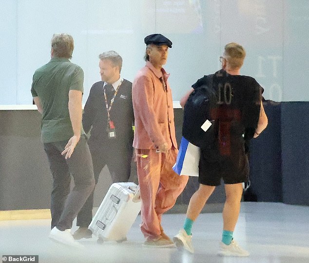 The 49-year-old arrived at the airport in a salmon pink leisure suit, including a matching shirt and loose trousers