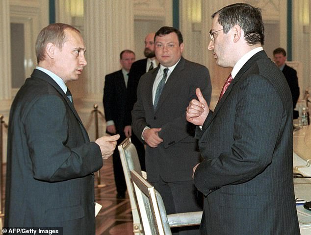 Russian President Vladimir Putin (L) talks to Chairman of the Board of Directors of oil company Yukos, Mikhail Khodorkovsky (R) during a meeting with members of the Russian Union of Industrialists and Entrepreneurs in the Kremlin, Moscow, May 31, 2001