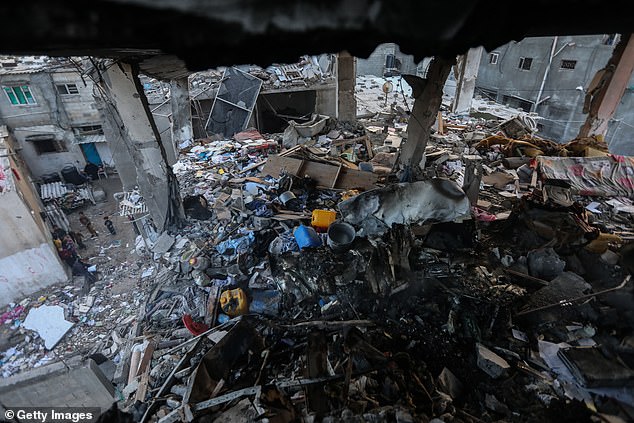 Palestinian civilians inspect the destruction caused by airstrikes on their homes on December 3, 2023 in Khan Yunis