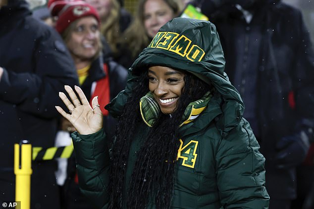 Simone's look: Biles stepped out in a thick green winter coat with a hood to protect her from the harsh elements at the outdoor football stadium