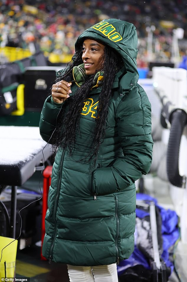 Biles stayed warm in the snow by wrapping up in a jacket with Owens' name and number on it