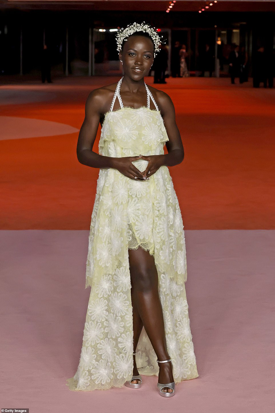 Lupita Nyong'o also attended the event in an ethereal, floral outfit.  She wore a pastel yellow dress with floral lace and a high-low skirt to show off her long, toned legs