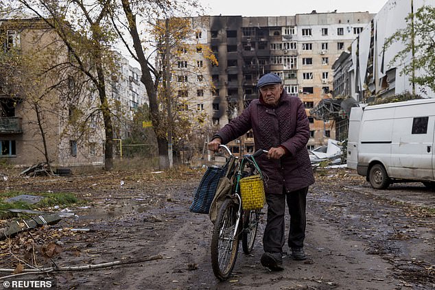 A local resident walks in front of damaged residential buildings, amid the Russian attack outside Ukraine, in the city of Avdiivka, Donetsk region, Ukraine, October 17, 2023