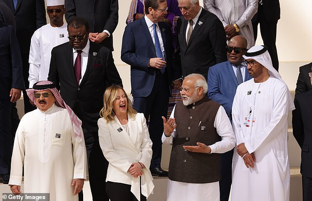 Italian Prime Minister Giorgia Meloni (CL) and Indian Prime Minister Narendra Modi laugh together during day one COP28 at Expo City Dubai on December 1, 2023