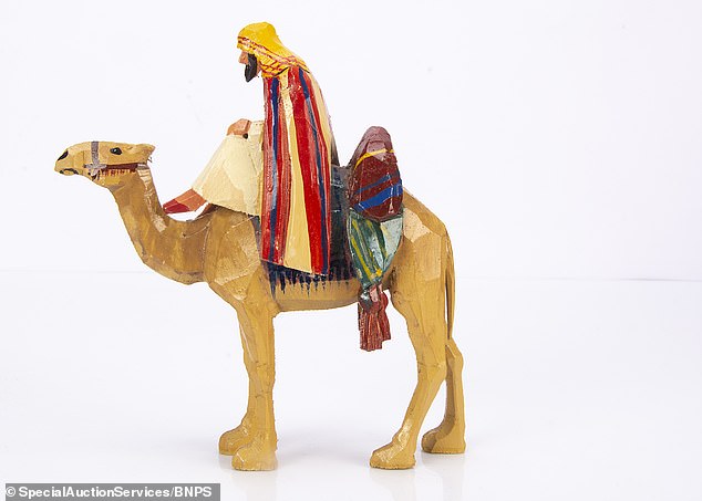 This statue of a man riding a toy camel is expected to sell for £300 at auction alone