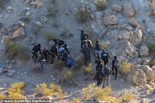 Illegal immigrants climb a mountain separating Mexico from Texas so they can sneak into El Paso