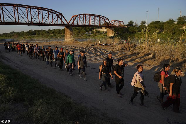 Migrants who have crossed the Rio Grande and entered the U.S. from Mexico line up for processing by U.S. Customs and Border Protection, September 23, 2023, in Eagle Pass, Texas