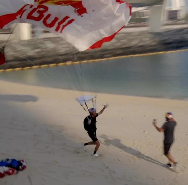 An ecstatic Brian is congratulated on the sandy beach after completing the first ever combined wakeskate base jump