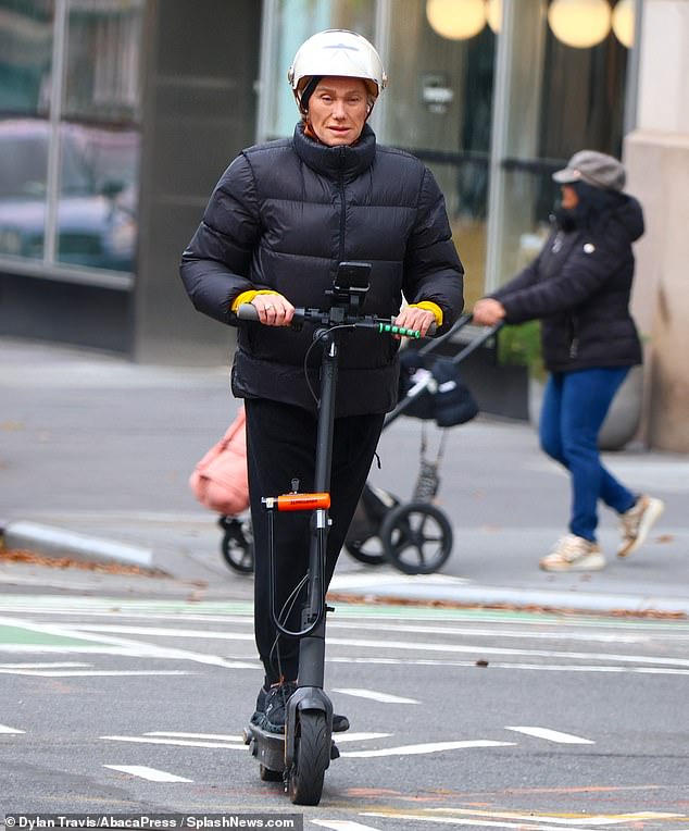 She stayed warm in a black puffer jacket over a yellow long-sleeved sports top and wore black sweatpants.