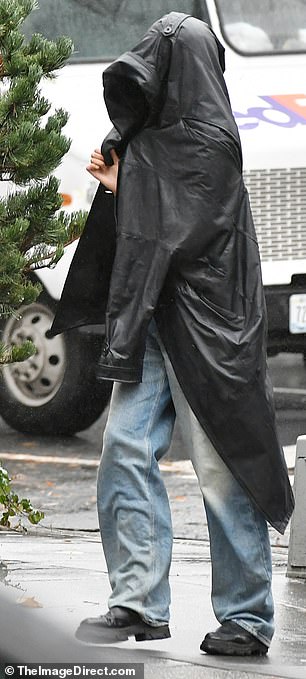 While Sasha wore nothing but a crop top and sweatpants, Malia tried to stay dry by draping a black leather trench coat over her head and shoulders.