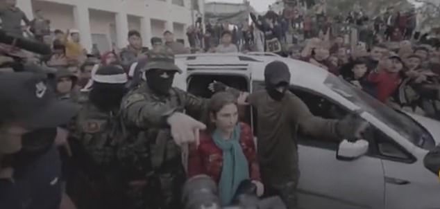 During her release, Amit is seen returning to Red Cross workers close to the Israel-Gaza border as a huge group of Palestinians surrounded her, cheering and chanting.