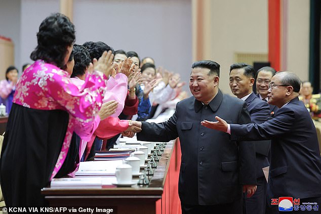 Kim Jon Un shakes hands with women at the National Mothers' Meeting in Pyongyang on Sunday - the first time the event has been held in 11 years