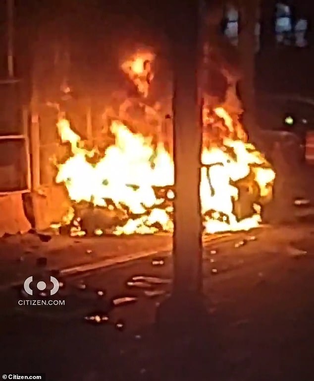 A close-up of the Lamborghini engulfed in flames after crashing into the pillar of an elevated Subway platform