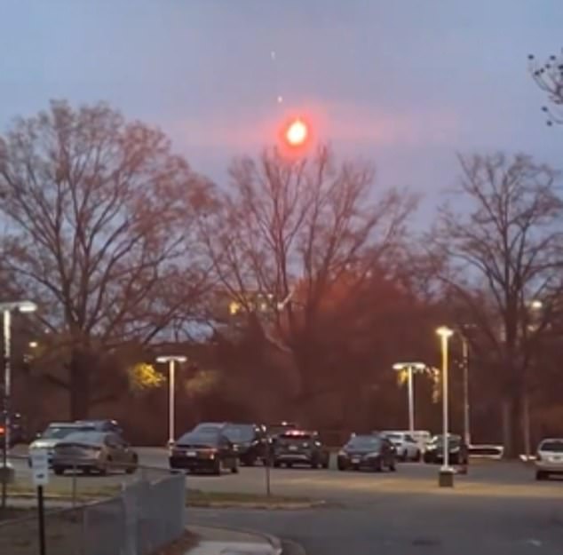 A flare lights up the darkening sky over Arlington, Virginia, Monday evening.  The pyrotechnic material was shot from a gun by a man before the house exploded in a huge fireball as a SWAT team prepared to enter.  The suspect remains missing