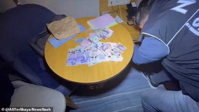 There is a stack of British banknotes spread out on a table