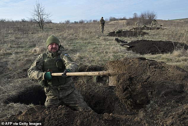 Ukrainian soldiers of the 42nd Mechanized Brigade dig trenches during a military field exercise in the Donetsk region on December 6