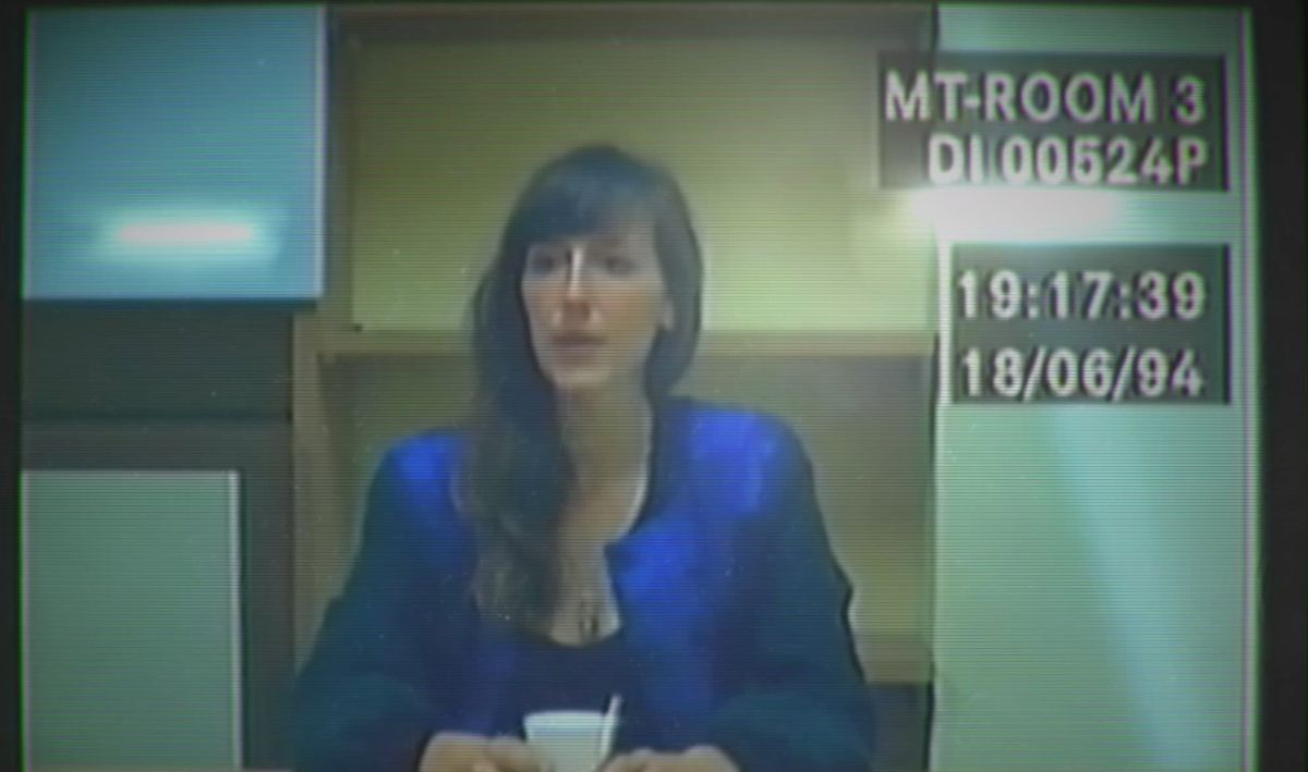 An image of actress Viva Seifert as her character in Her Story, sitting in an interrogation room