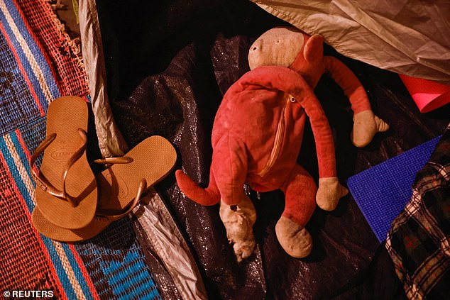 A toy and a pair of slippers stand at the entrance to an open tent