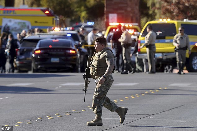 A police officer works at the scene of the shooting that left at least three people dead