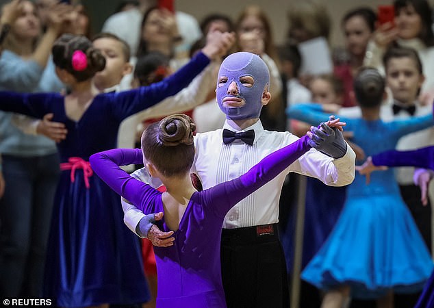 The brave schoolboy held his head high as he took his partner to the dance floor during a performance with other children at his school