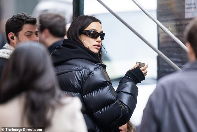 Irina looked beautiful in a black puffy Nike jacket over a black hoodie and pants, with hoop earrings and small framed sunglasses