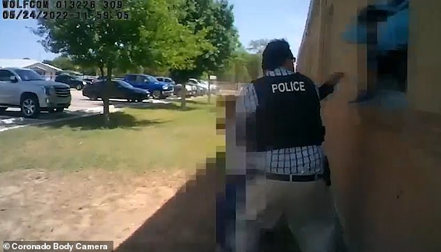 Another new video shows police officers running to a window before helping children escape.  Students can be seen frantically jumping out of windows before fleeing