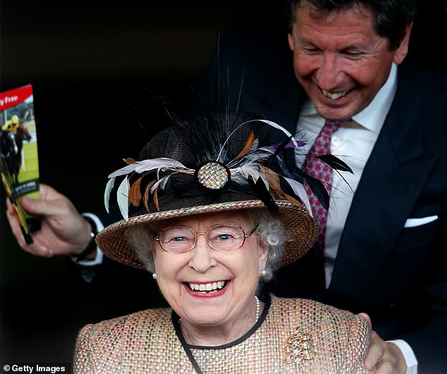 Like her racing manager, John Warren, the queen smiles with joy as horse Sign Manual crosses the finish line to win the Dreweatts Handicap Stakes at Newbury in April 2013.