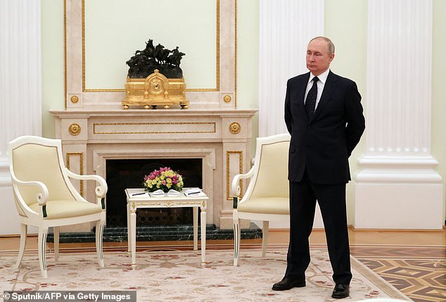 Vladimir Putin stands in a room ahead of a meeting with his Belarusian counterpart at the Moscow Kremlin on March 11, 2022