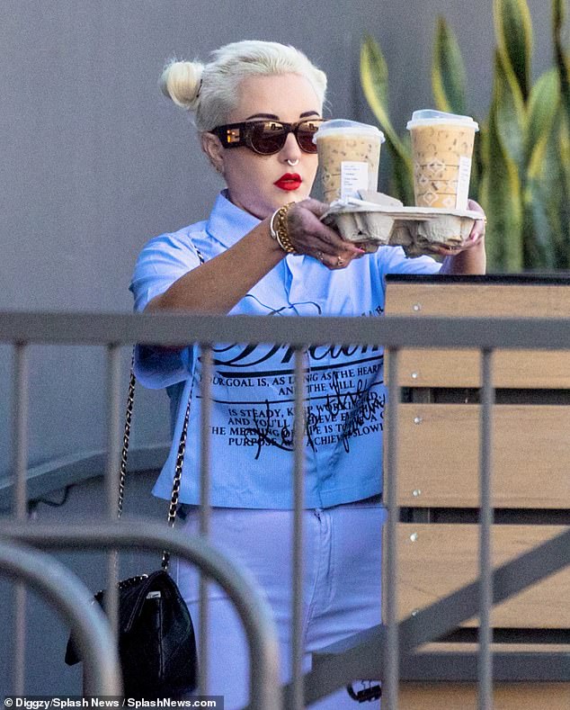 Amanda impressively juggled two venti-sized drinks on a cardboard tree as she headed outside