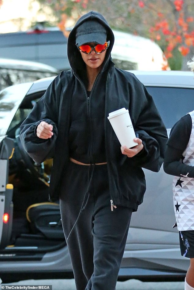 She kept a low profile with a black baseball cap and her hood up, shielding her eyes with red reflective sunglasses.