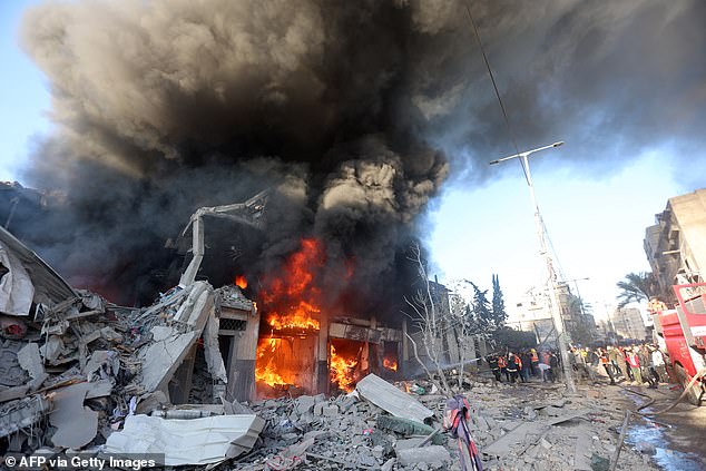 Firefighters battle flames in a building hit by an Israeli attack in Khan Yunis in the southern Gaza Strip